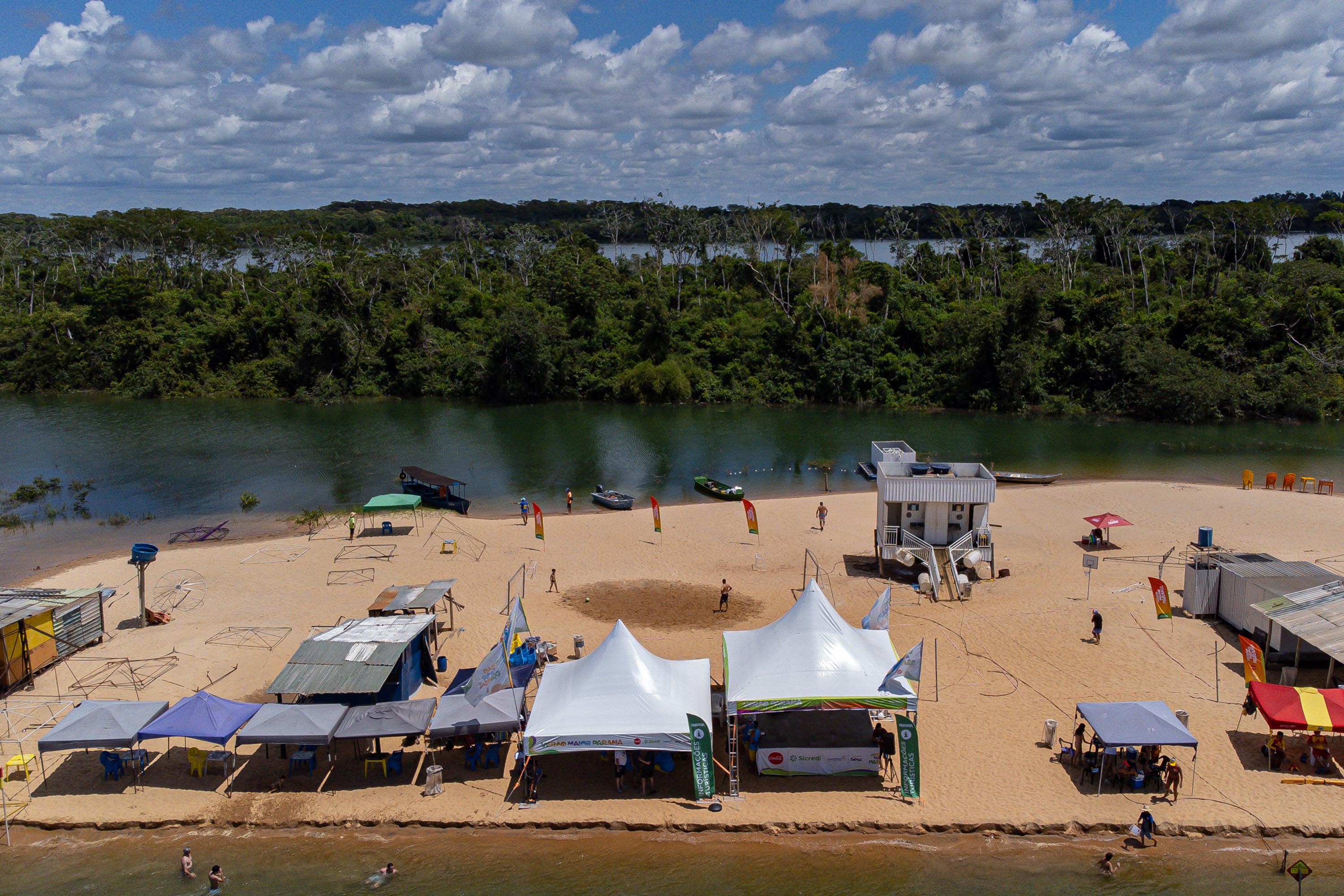 Margem do Rio Paraná com barracas próximas ao rio.