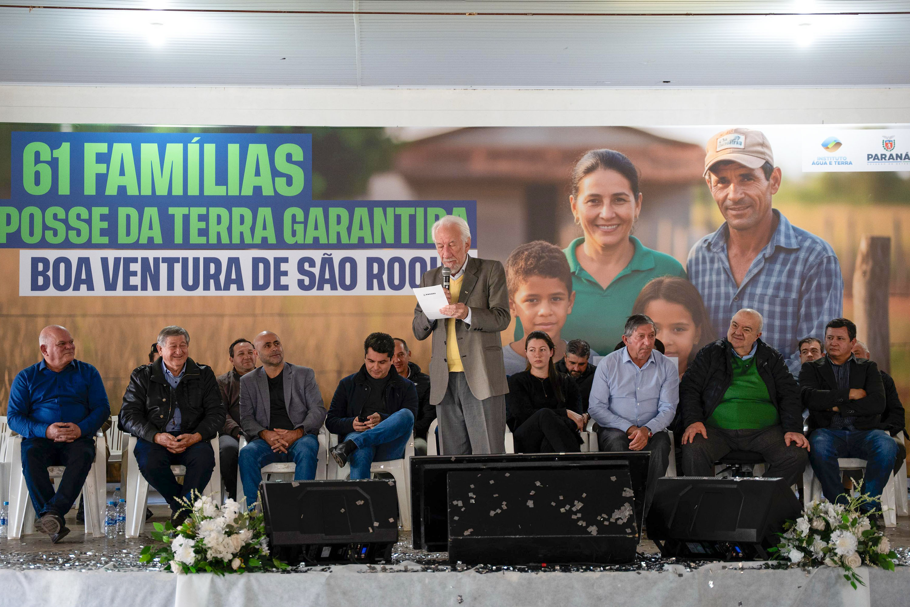 Foto de autoridades em evento de entrega dos títulos de regularização