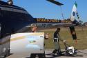 equipe PM e IAT próximos ao helicoptero pousado no chão
