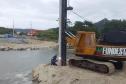 Trator e técnico do IAT fazendo a entalação de uma estaca na margem do Rio Matinhos