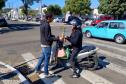 Representante do IAT entregando mudas a um civil em sua motocicleta. 