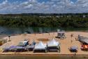 Margem do Rio Paraná com barracas próximas ao rio.