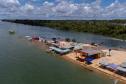 Margem do Rio Paraná com barracas próximas ao rio.