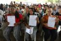 Beneficiárias posando para foto com o título de regularização em mãos