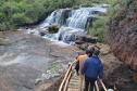 Visitantes passando por uma cachoeira