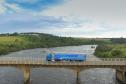 Caminhão da DAF passando por uma ponte com a natureza paranaense ao fundo