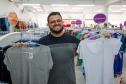 Comerciante com blusas nas mãos