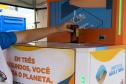 Foto de pessoa depositando garrafa na máquina de reciclagem
