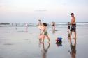 Foto de família passeando em praia