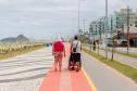 Foto de casal andando na ciclovia da orla de Matinhos