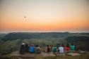 Foto de pessoas vendo o nascer do sol em montanha