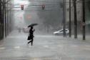 INDIVÍDUO EM MEIO A CHUVA TORRENCIAL NO MEIO DA RUA EM CURITIBA