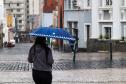TRANSEUNTE SE PROTEGENDO DA CHUVA NO LARGO DA ORDEM