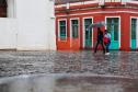 TRANSEUNTES SE PROTEGENDO DA CHUVA NO LARGO DA ORDEM