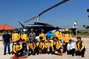 VOLUNTARIOS POSANDO FRENTE AO HELICOPTERO
