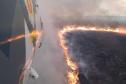 Foto de helicóptero sobrevoando incêndio