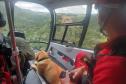 Foto de interior de helicóptero sobrevoando trilha