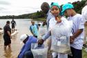 Foto de autoridades e crianças durante soltura de peixes