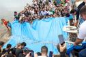 Foto de autoridades e crianças durante soltura de peixes