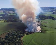 IMAGEM AÉREA MOSTRANDO ÁREA DE DESMATAMENTO COM INTENSA FUMAÇA