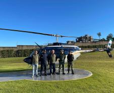 EQUIPE DE SERVIDORES POSANDO A FRENTE DO HELICOPTERO UTILIZADO PARA FISCALIZAÇÃO E MONITORAMENT