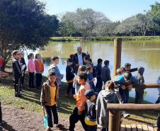 Crianças em aula ambiental em frente á lago