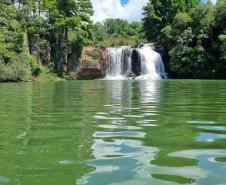 Foto de superfície de rio com um cachoeira ao fundo