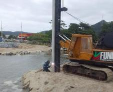 Trator e técnico do IAT fazendo a entalação de uma estaca na margem do Rio Matinhos