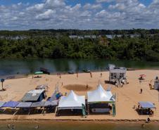 Margem do Rio Paraná com barracas próximas ao rio.