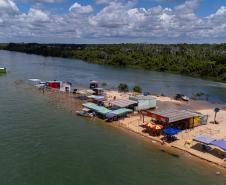 Margem do Rio Paraná com barracas próximas ao rio.
