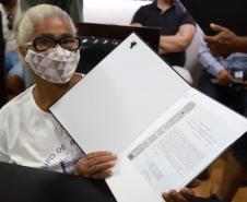 Beneficiária com o título de regularização em mãos.