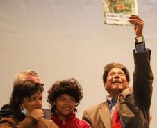 Beneficiária comemorando a aquisição do título de regularização. 