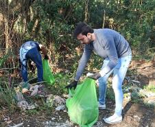 Voluntários recolhendo lixo dentro de uma UC do IAT