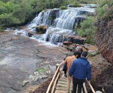 Visitantes passando por uma cachoeira
