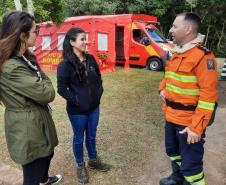 Visitantes conversando com membro da equipe do corpo de bombeiros