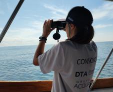Agente do consórcio observando o mar com binóculos