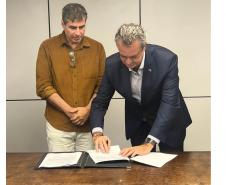 Diretor-presidente do IAT assinando documento