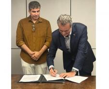 Diretor-presidente do IAT assinando documento