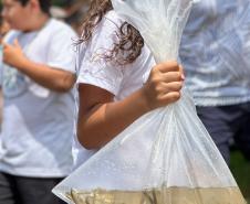 Criança com sacola com água transportando os peixes a serem soltos