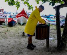 Voluntário recolhendo o lixo da praia