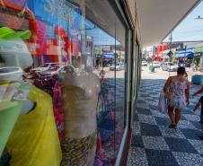 Clientes passando em frente ao comércio local