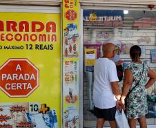 Clientes passando em frente ao comércio local