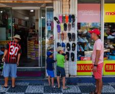 Clientes passando em frente ao comércio local