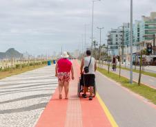 Foto de casal andando na ciclovia da orla de Matinhos