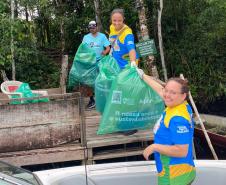 Voluntários coletando resíduos e posando para a foto