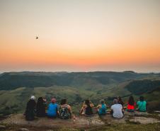 Foto de pessoas vendo o nascer do sol em montanha