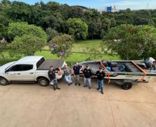 SERVIDORES POSANDO PARA FOTO A FRENTE DE VEÍCULO AUTO E HIDRO MOTOR
