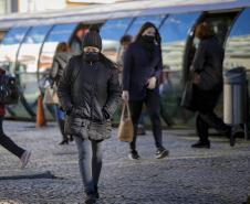 TRANSEUNTE ANDANDO FRENTE A UMA ESTAÇÃO TUBO NO INVERNO