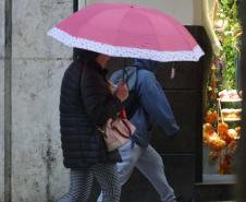PESSOAS CAMINHANDO NA CHUVA