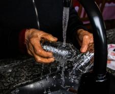Foto de beneficiada por poço lavando louça